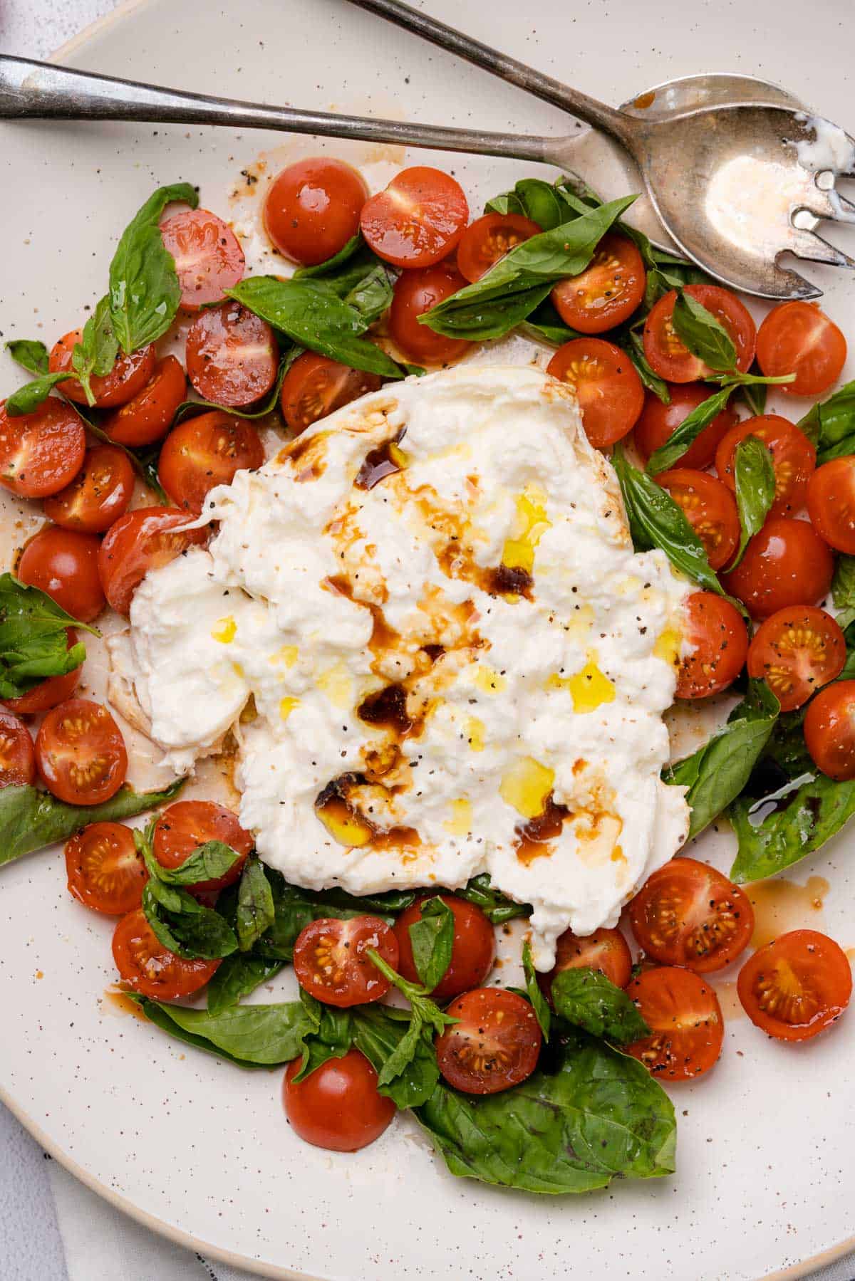 creamy burrata caprese salad drizzled with balsamic vinegar olive oil and salt and pepper