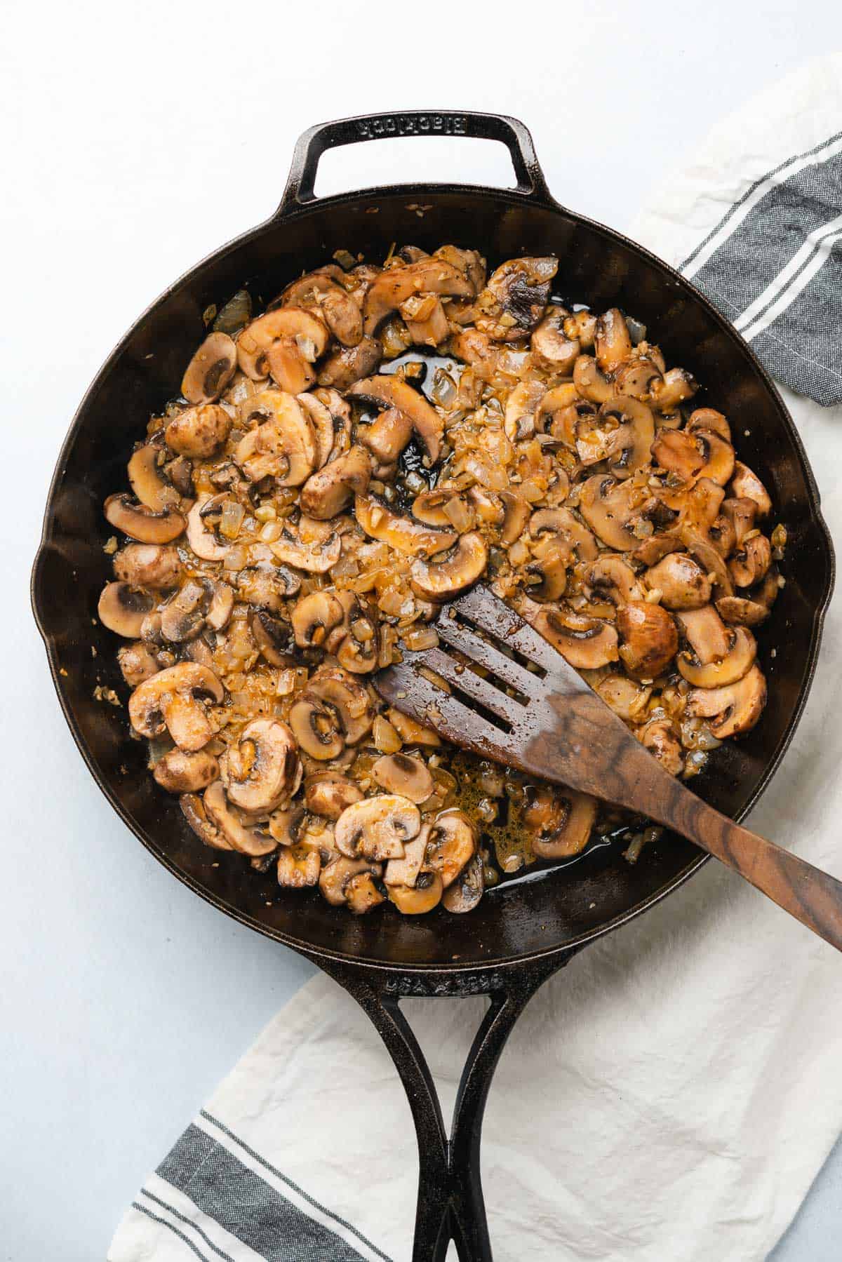 mushrooms cooking in a cast iron skillet