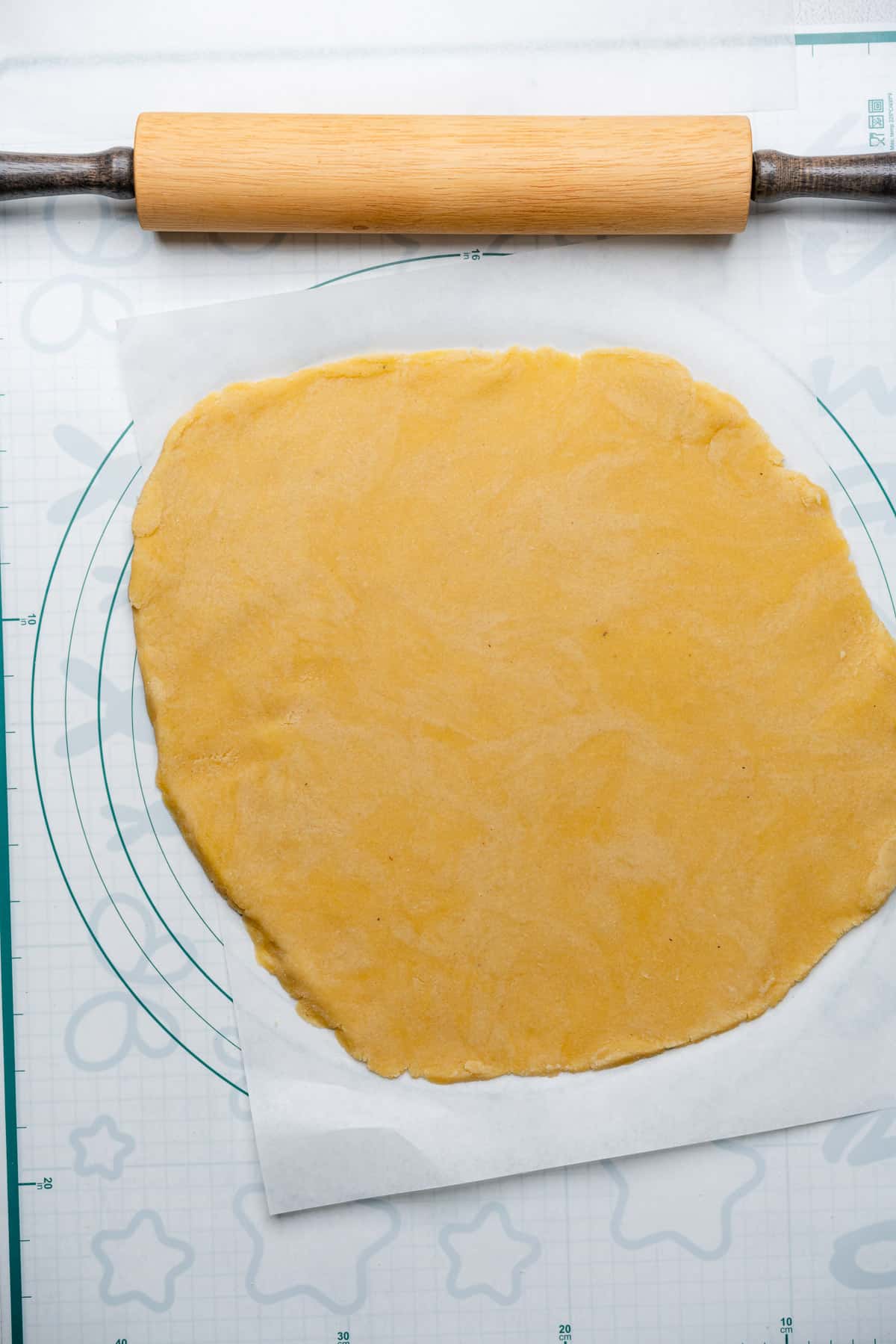 gluten free pie crust dough rolled out into a circular shape with a rolling pin