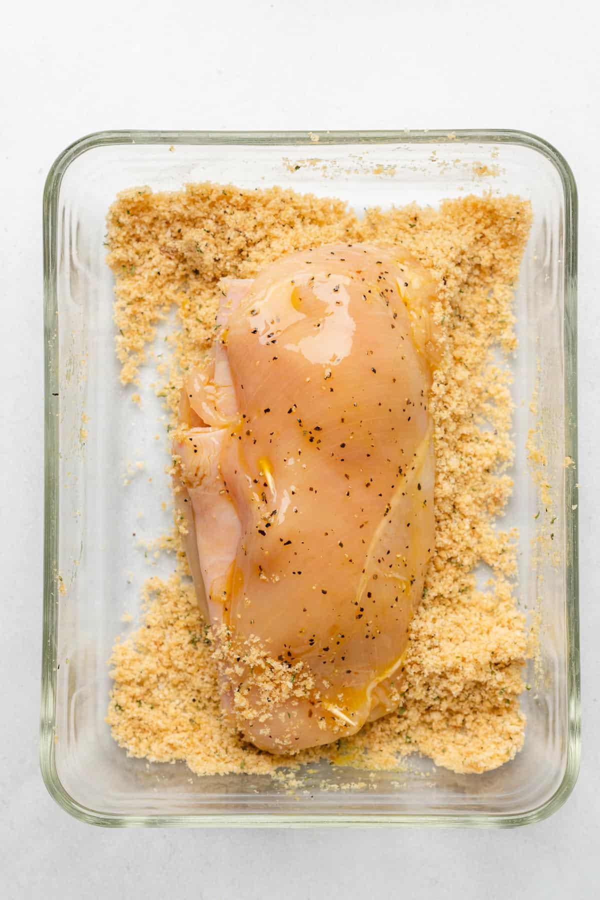 raw chicken breast in pork rind crumbs