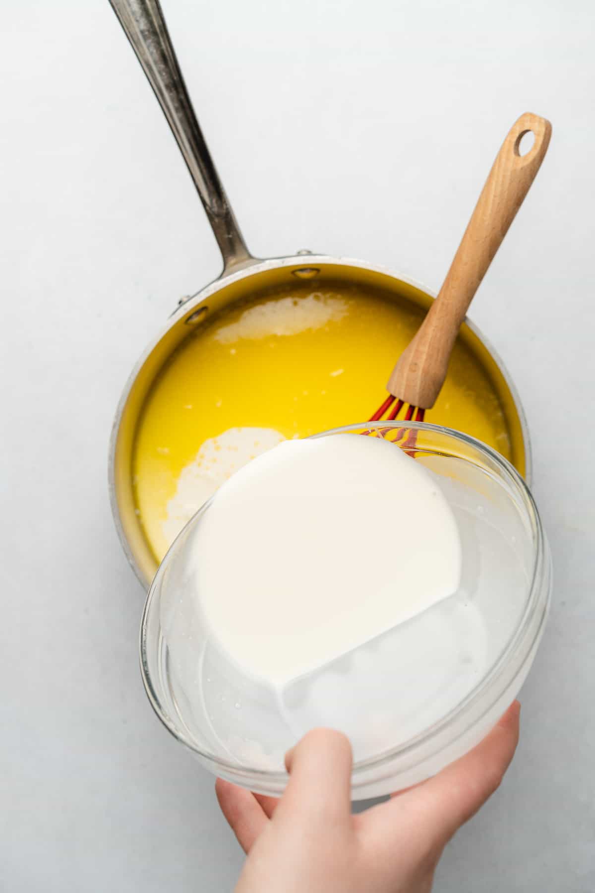 melted butter in a sauce pan with heavy whipping cream being poured in