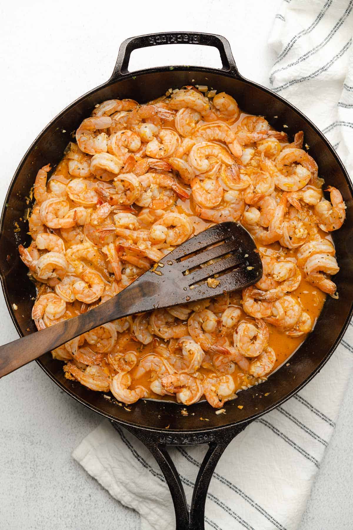 cooked shrimp in a cast iron skillet with broth