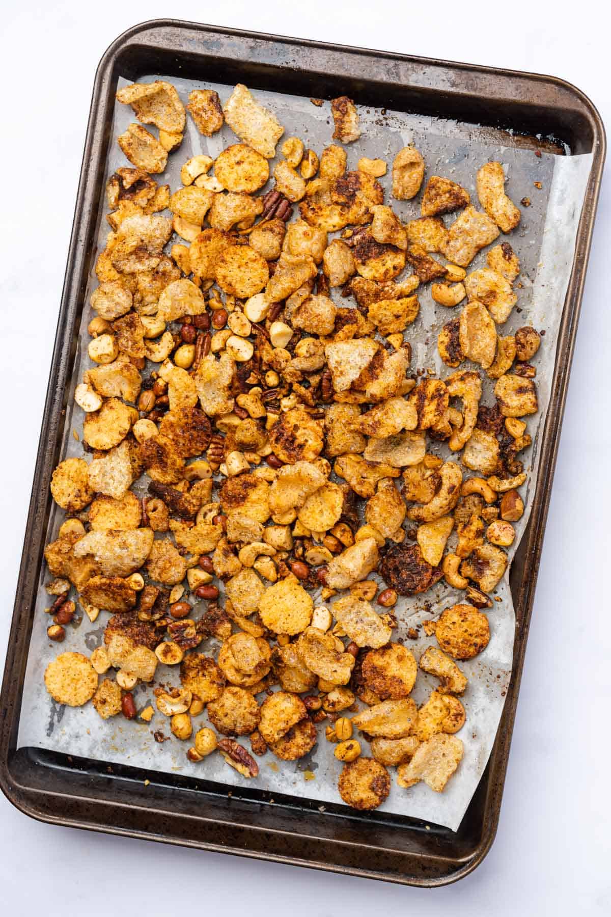 baked keto snack mix with pork rinds on a baking sheet