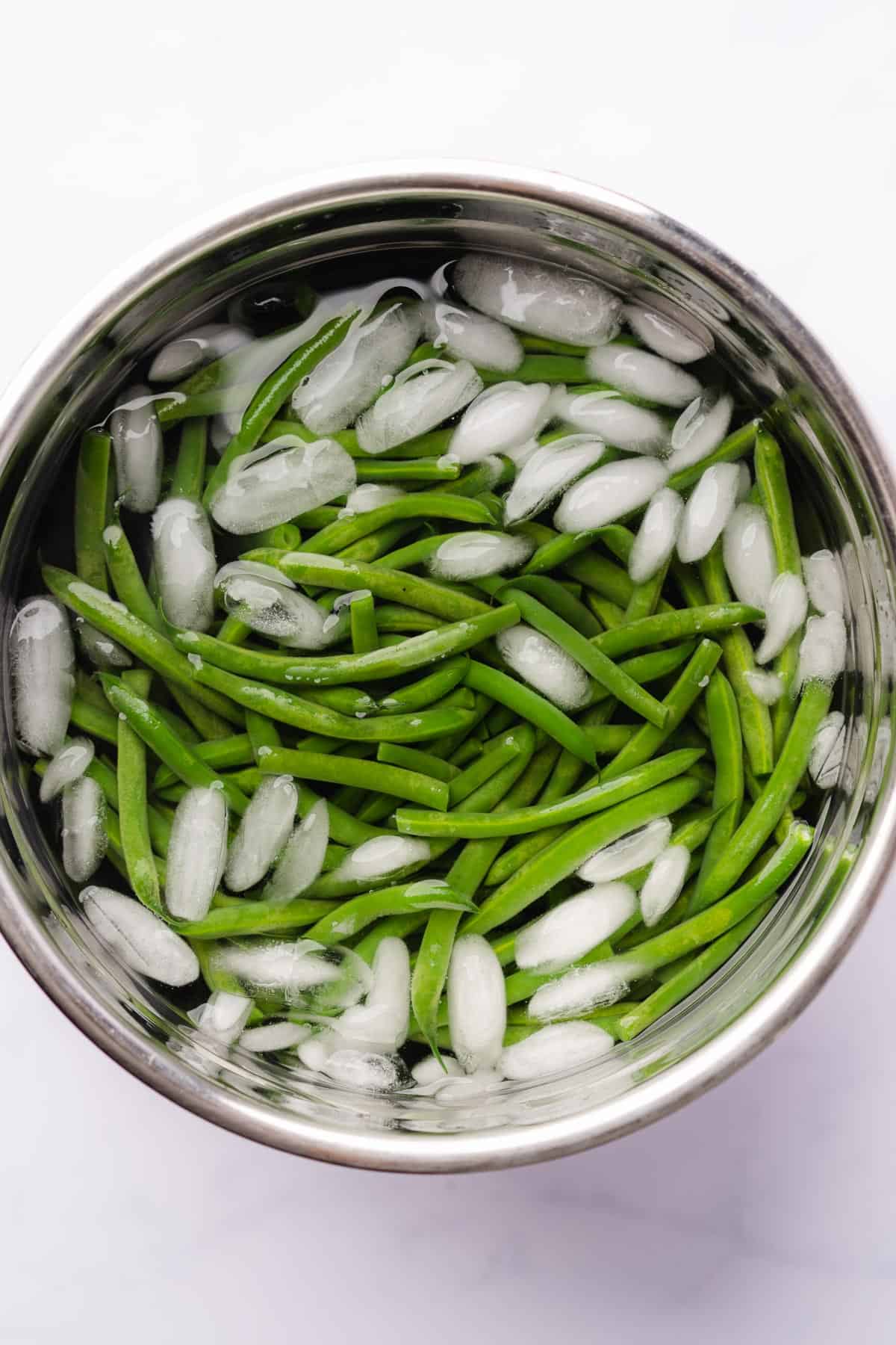 vibrant fresh green beans in an ice bath