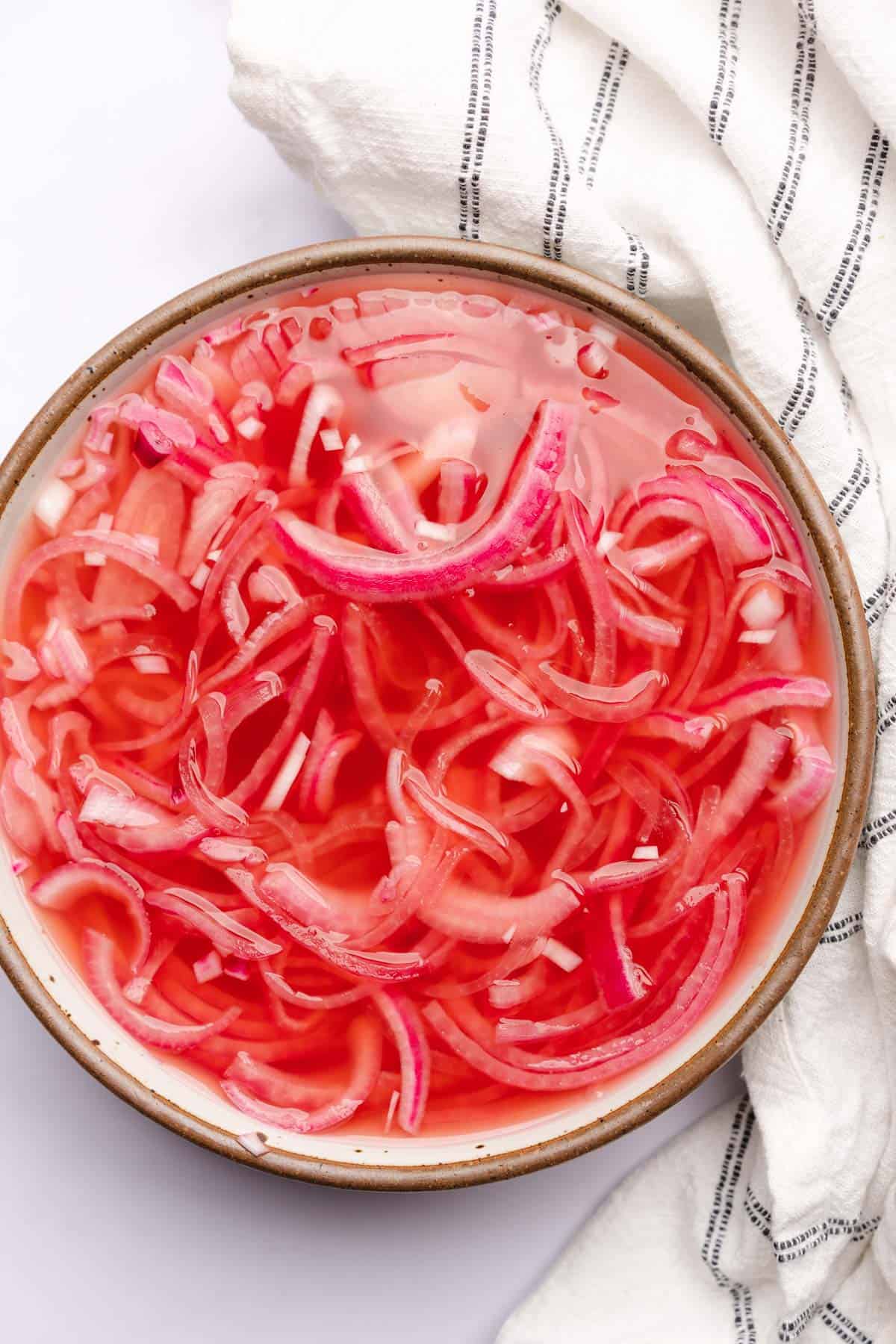 pickled red onions in a large ceramic bowl
