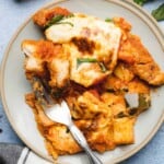 plate full of luscious keto chicken parmesan casserole with fresh basil and melted mozzarella cheese