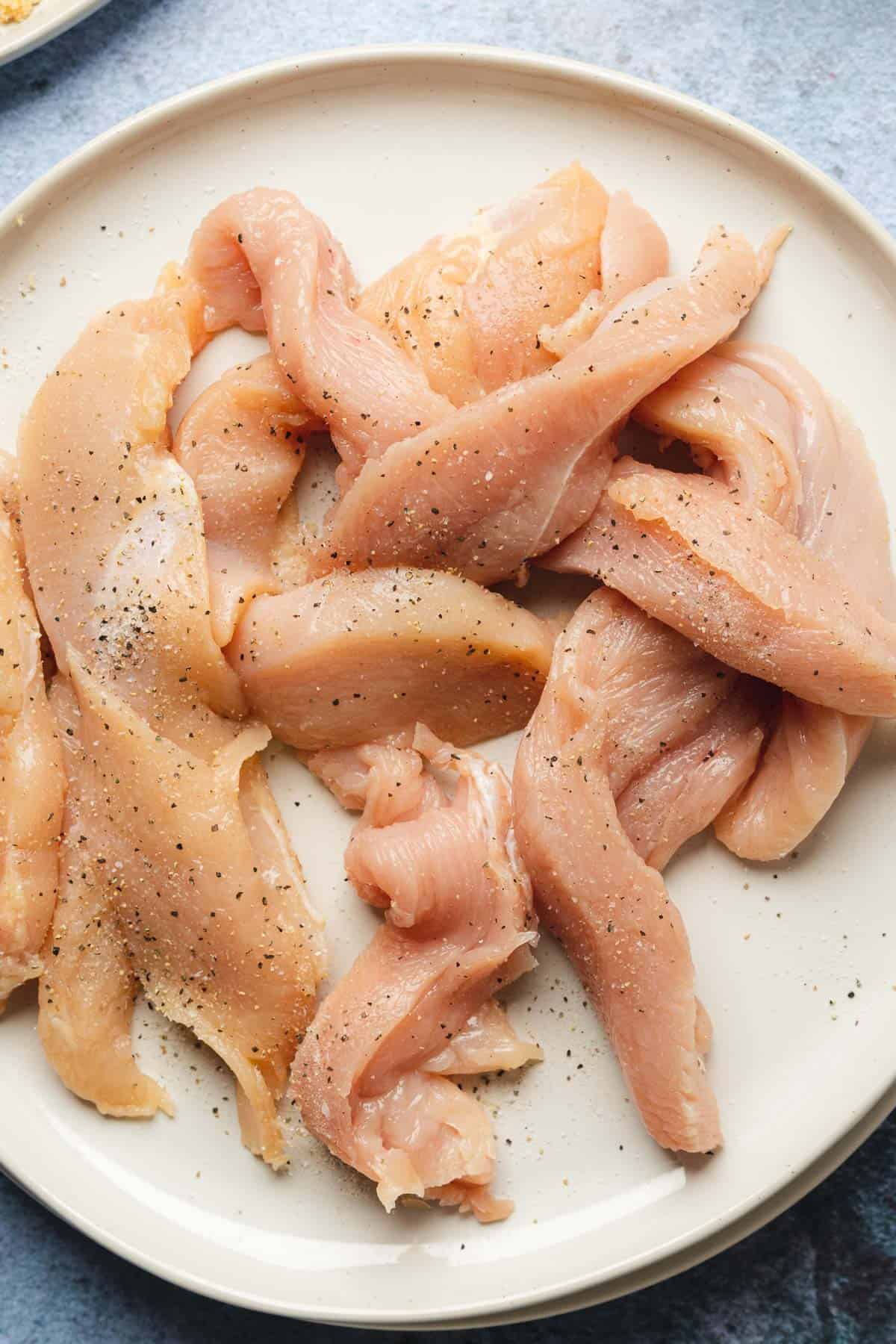 raw chicken strips on a plate