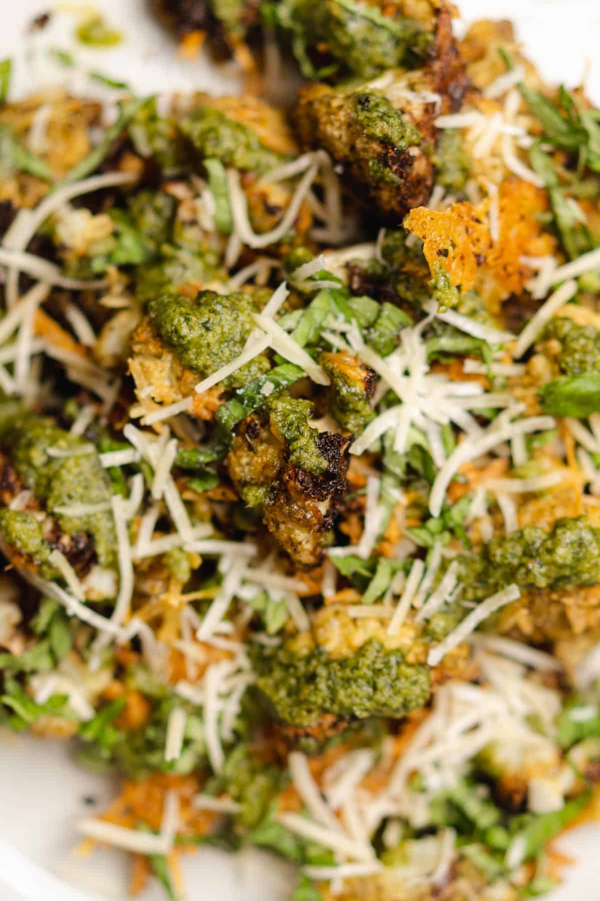 close up shot of crispy pesto drenched cauliflower with parmesan cheese