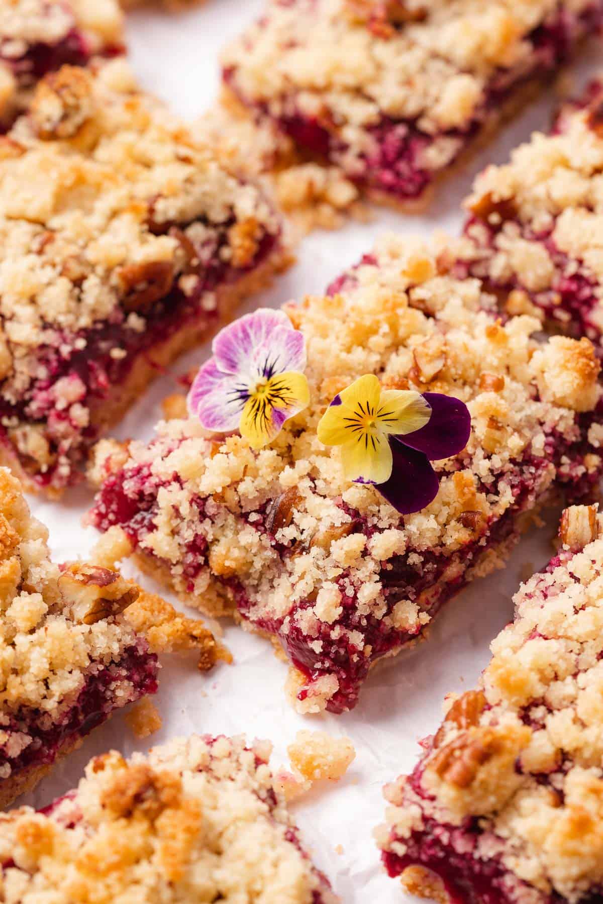 plum bars with crumble topping topped with edible flowers
