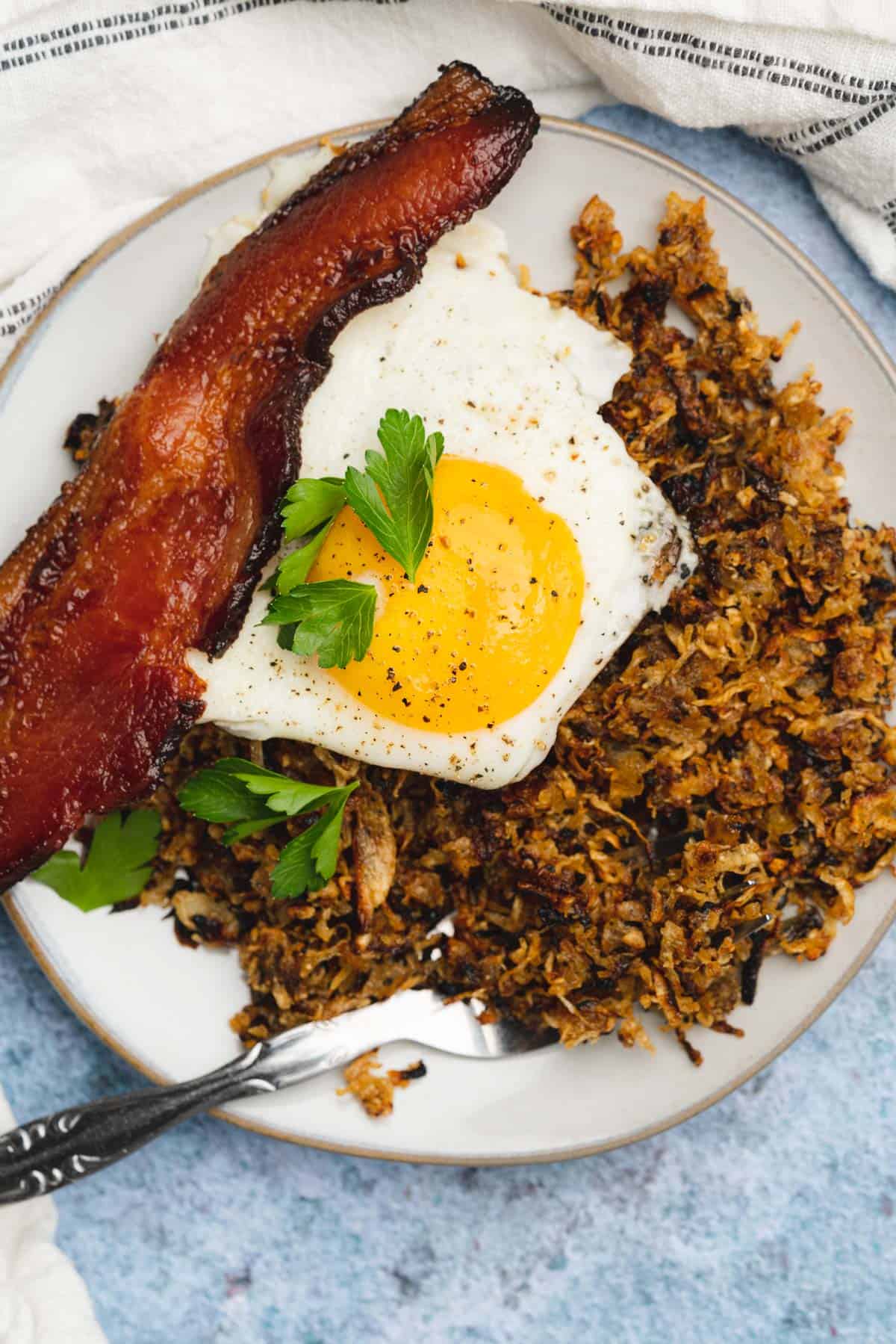 super crispy turnip hash browns with a sunny side up egg, bacon and parsley