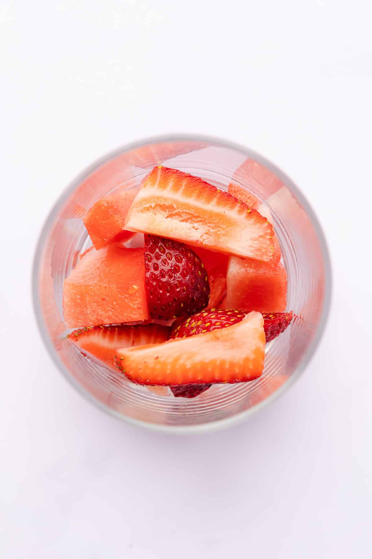 strawberries and watermelon in the bottom of a glass