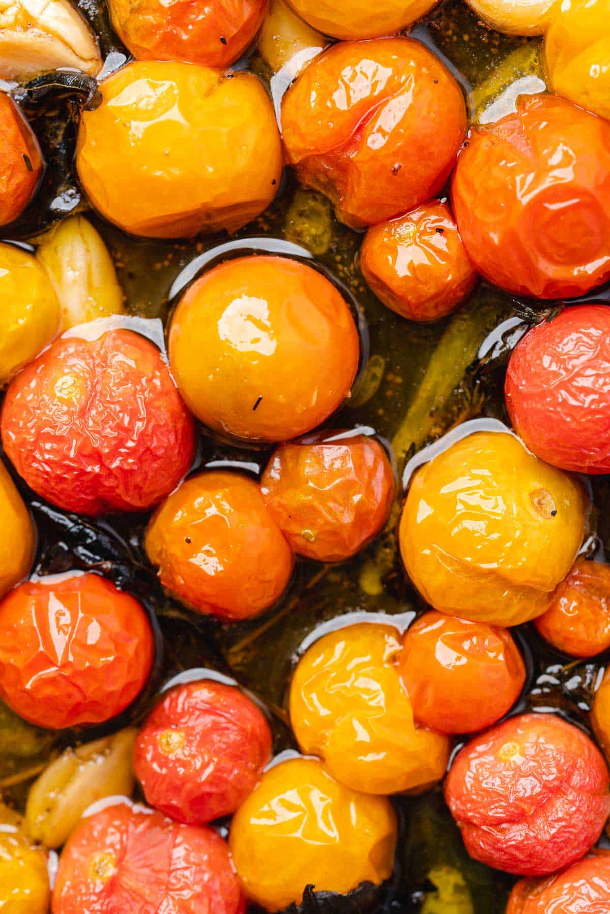 up close macro shot of cherry tomatoes roasted on a black cast iron baking sheet