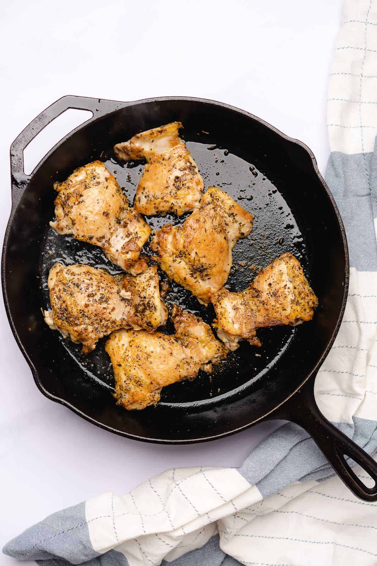 seared and seasoned chicken thighs in a cast iron skillet