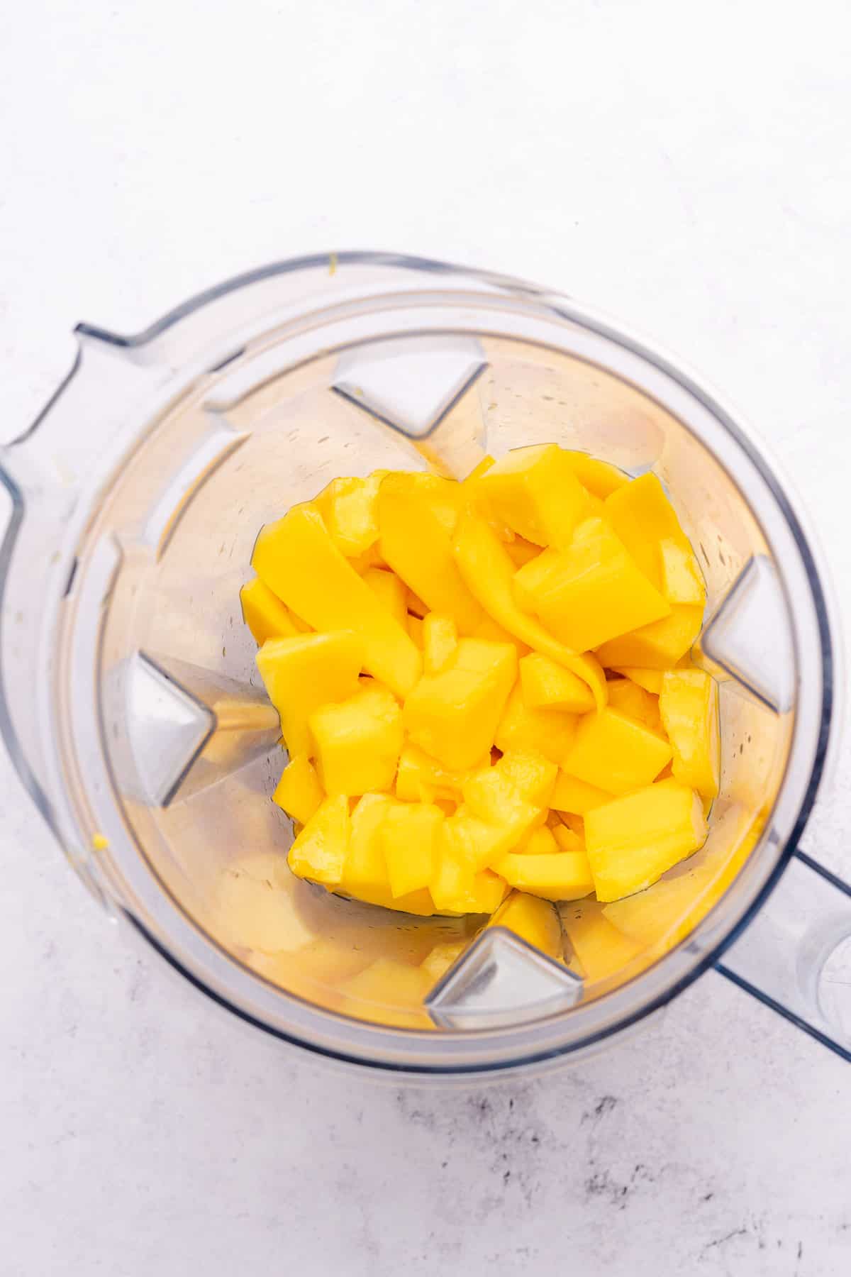 mango in a blender preparing to be blended