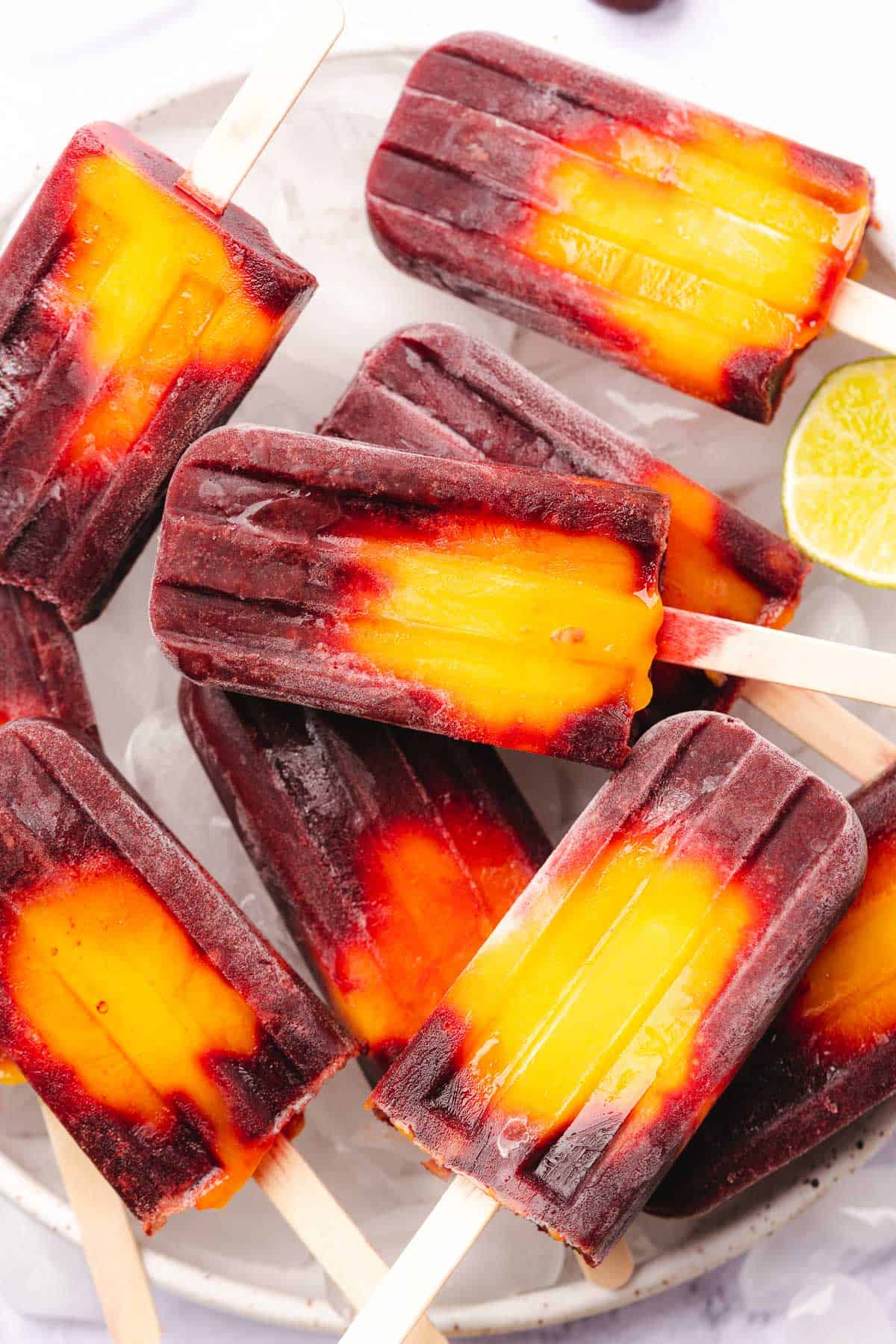 a stack of mango cherry popsicles with lime