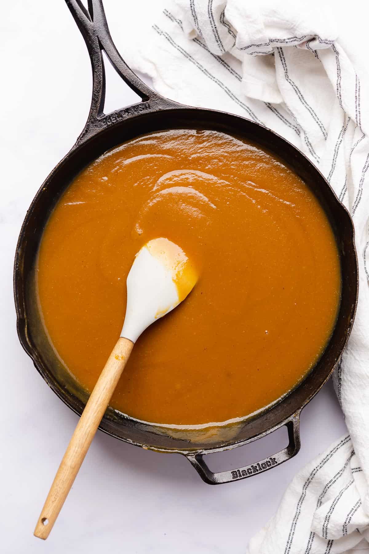 mango habanero sauce in a cast iron skillet with a rubber spatula