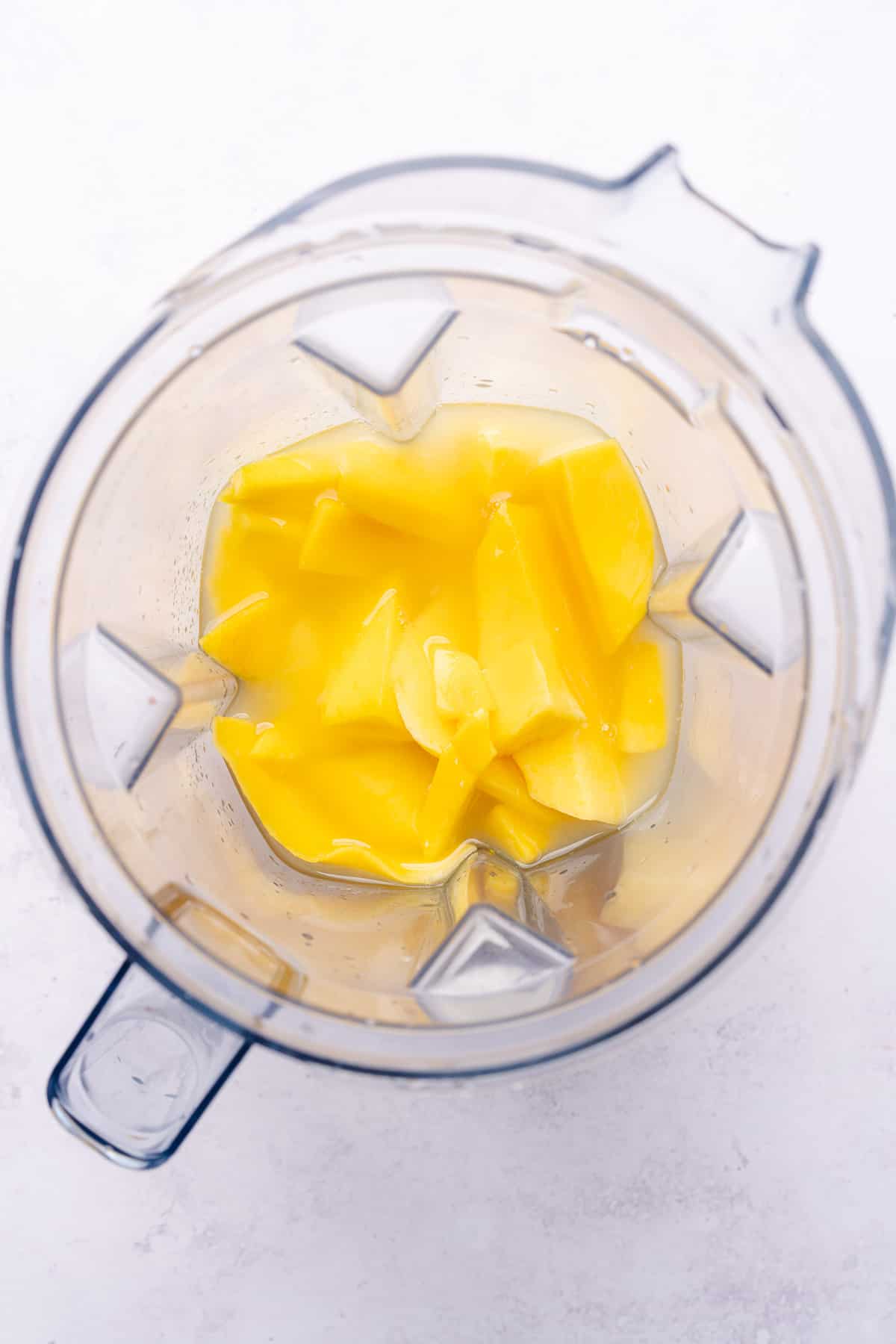 blending fresh mango, lime juice and simple syrup in a vitamix blender