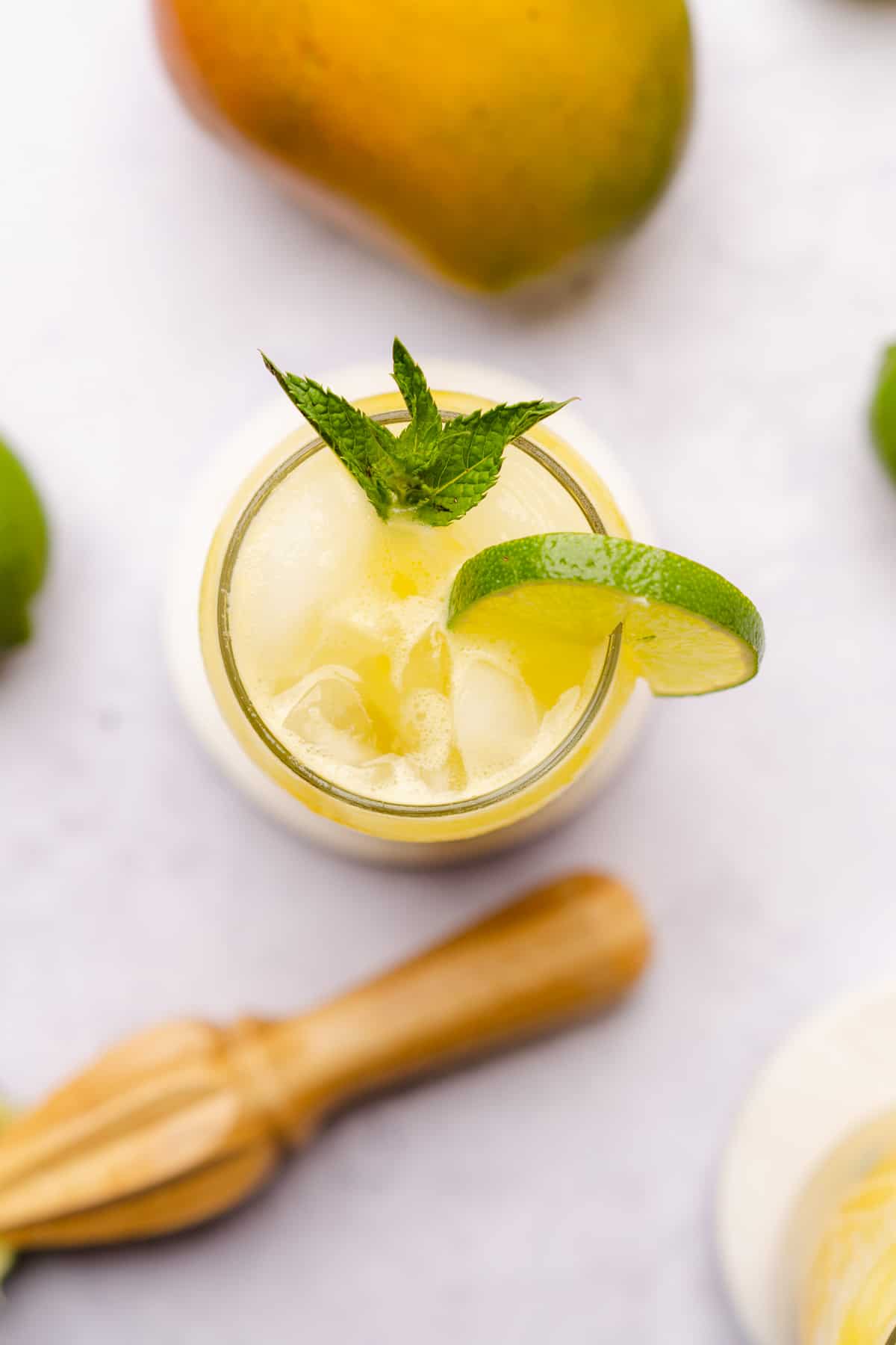 flat lay shot of a mango mojito with a citrus reamer nearby