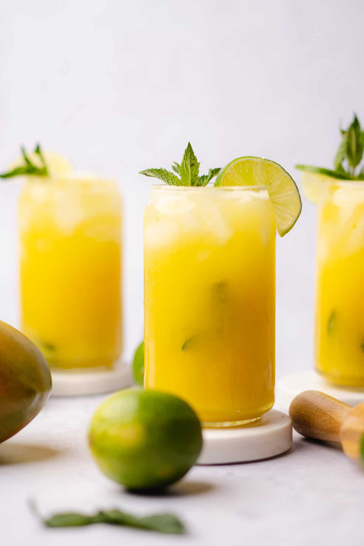 lovely glasses of mango mojitos with fresh limes and mint