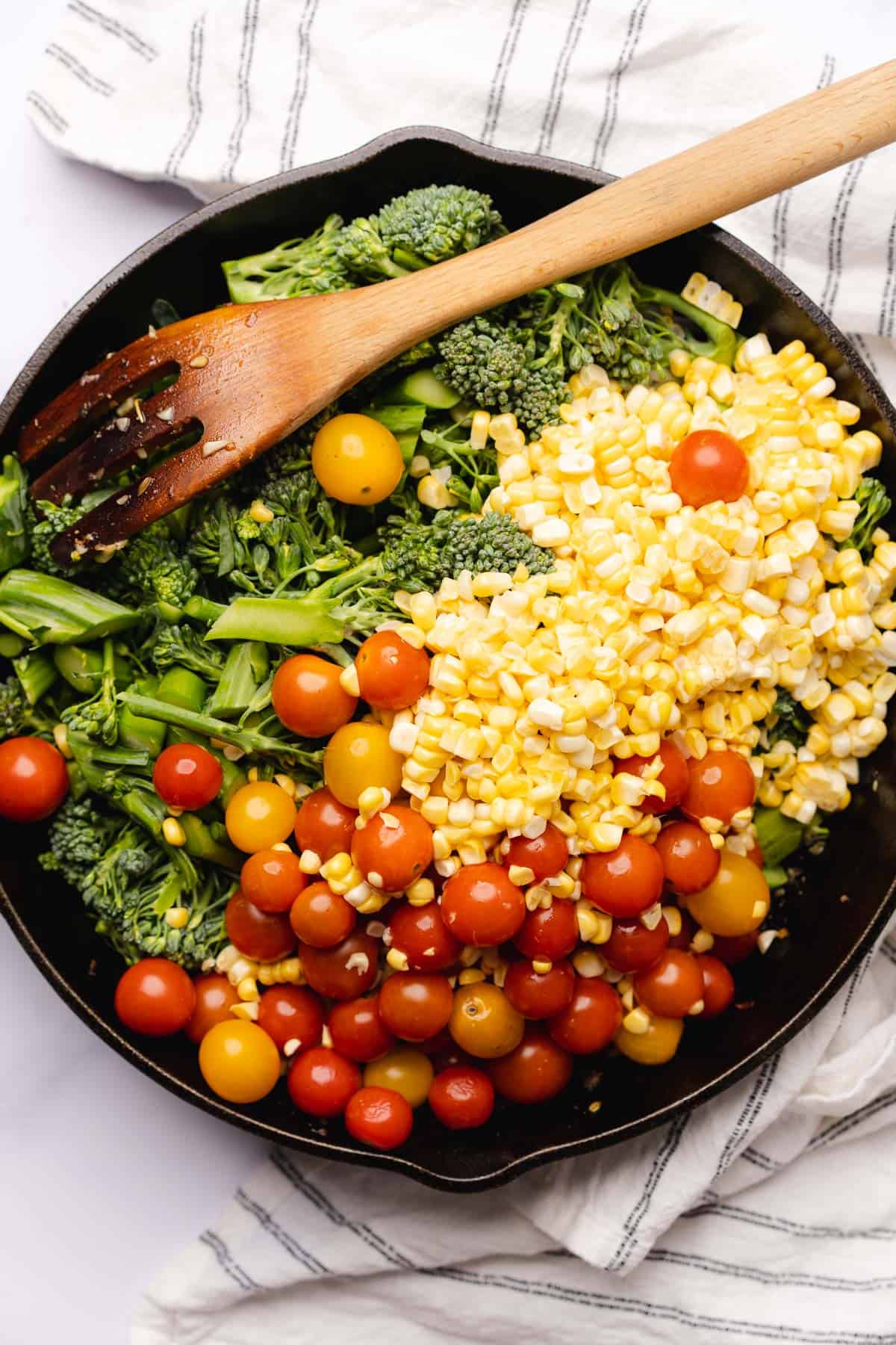 tomatoes, corn and broccolini in a cast iron skillet 