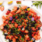 Watermelon berry salad with gorgeous edible flowers with text for pinterest