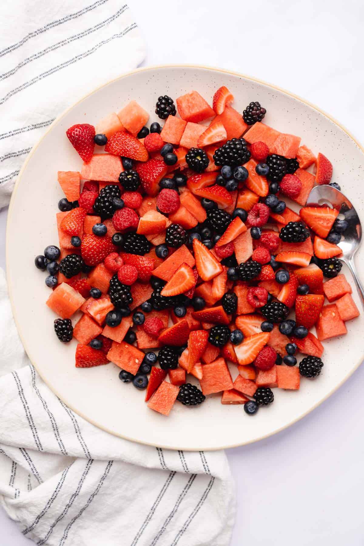 watermelon on a plate with blackberries, raspberries, blueberries and strawberries 