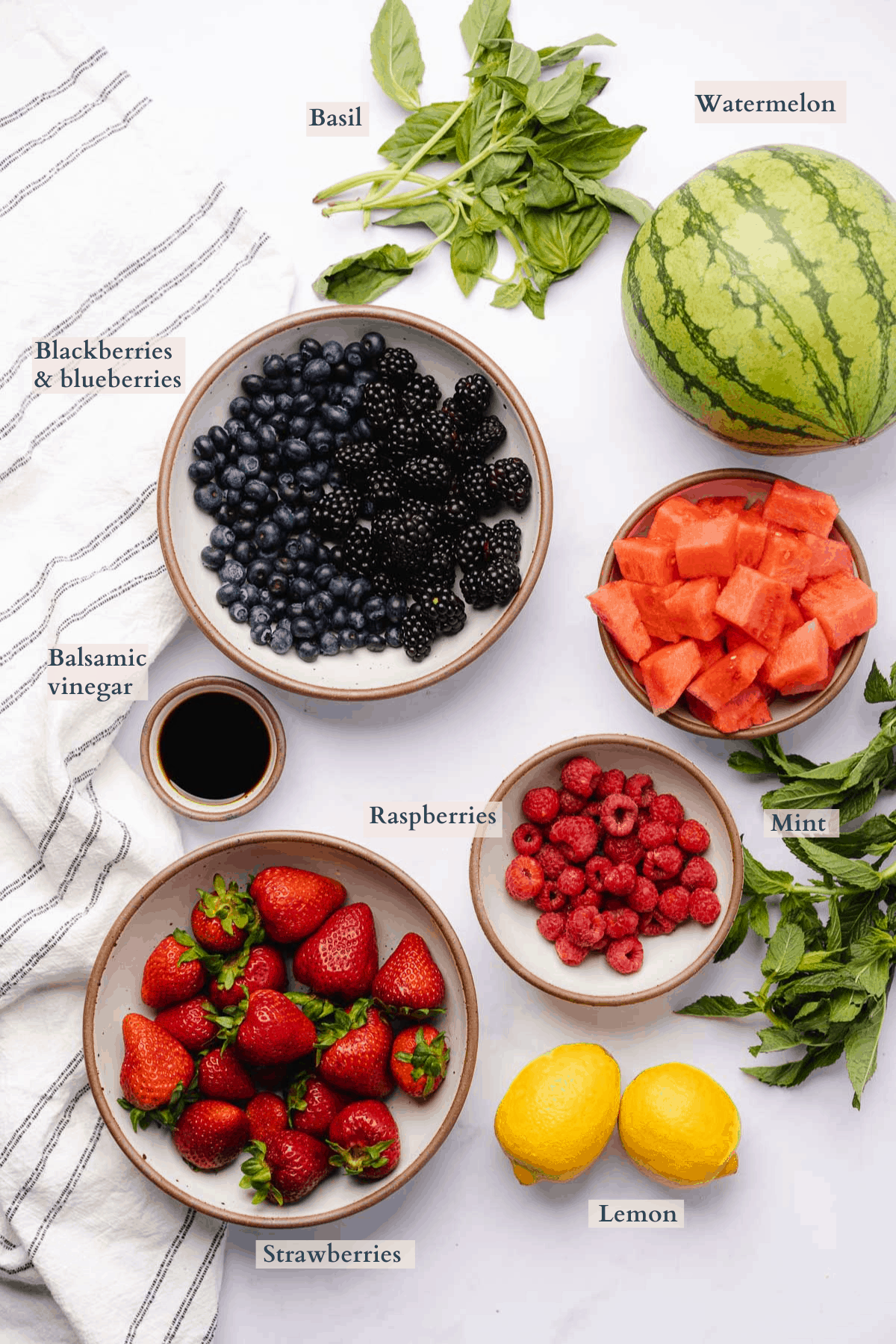 ingredients to make watermelon berry salad with text to denote different ingredients