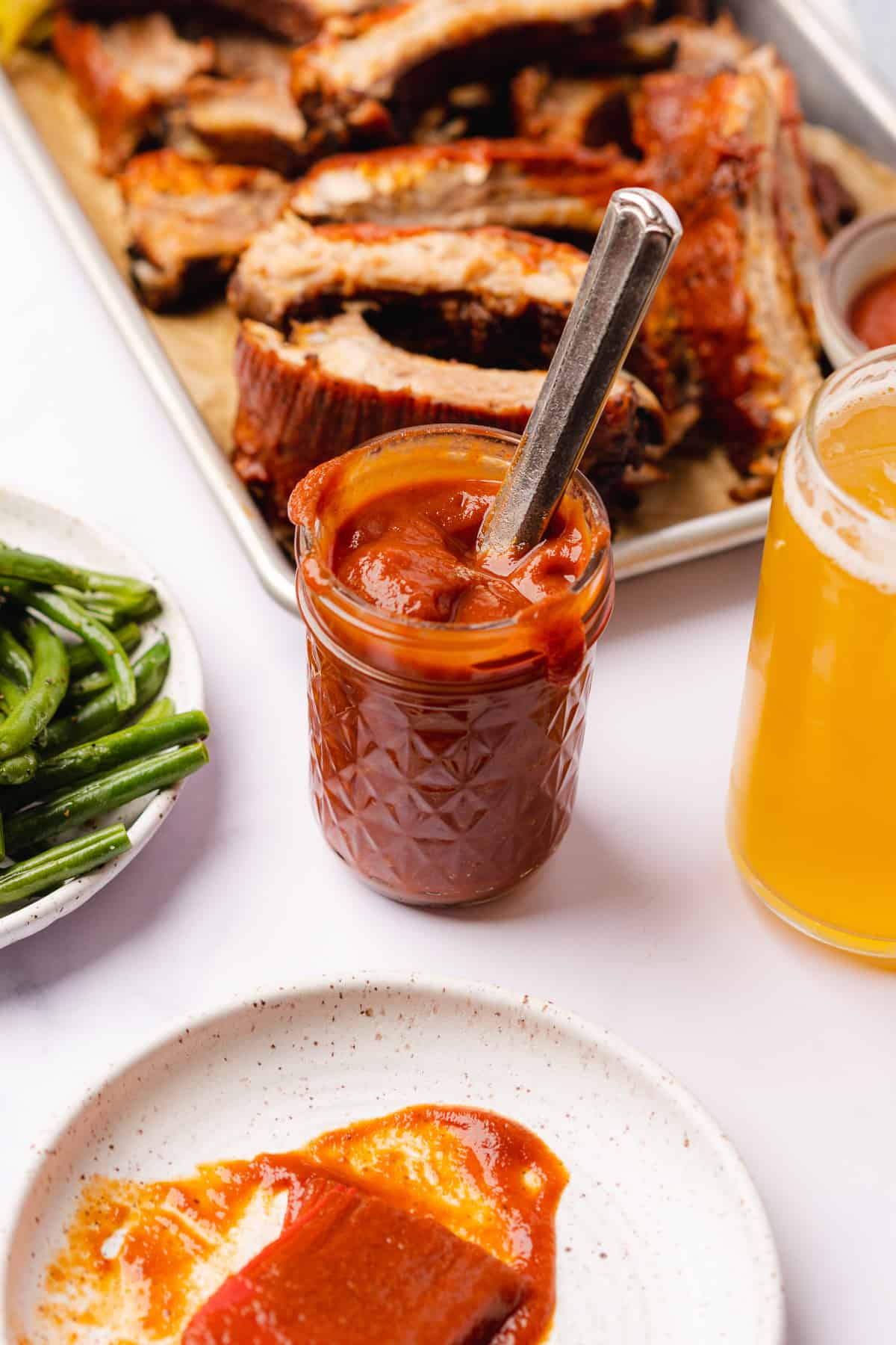 keto bbq sauce with homemade keto pork ribs next to a beer