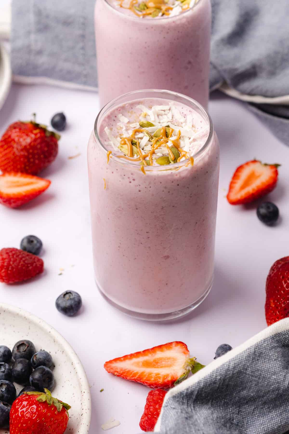 gorgeous keto berry smoothie with fresh berries, coconut flakes, pepitas and peanut butter
