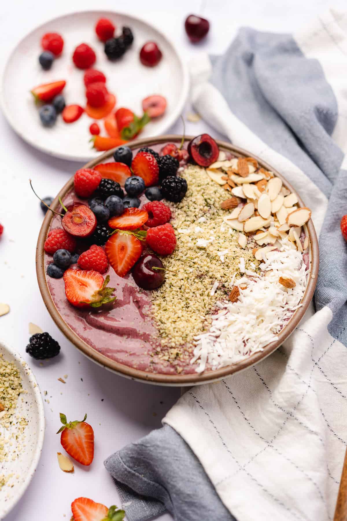 beautiful acai bowl with lots of fruit, nuts, seeds and hemp hearts