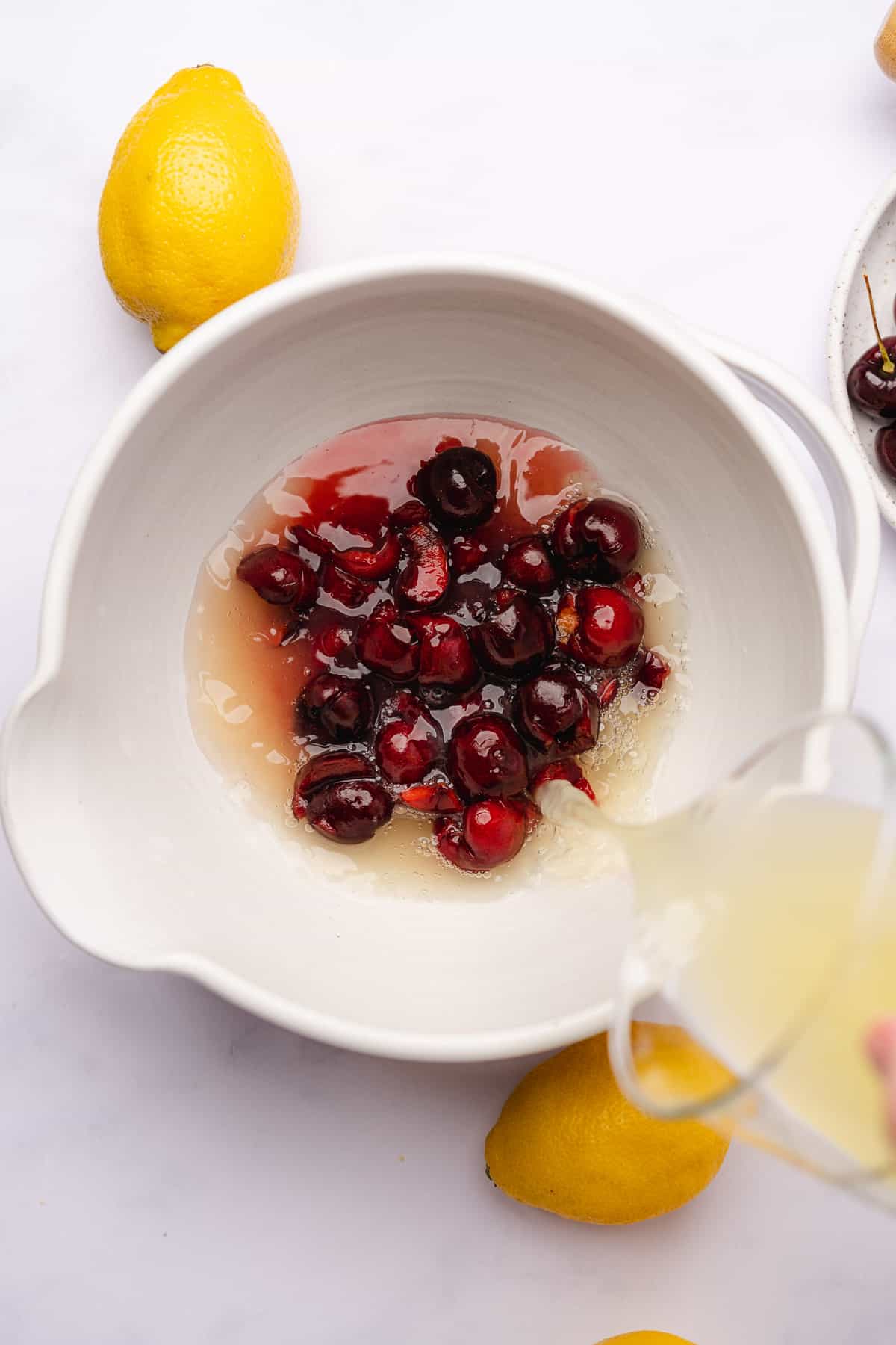 pouring in fresh lemon juice to a ceramic bowl