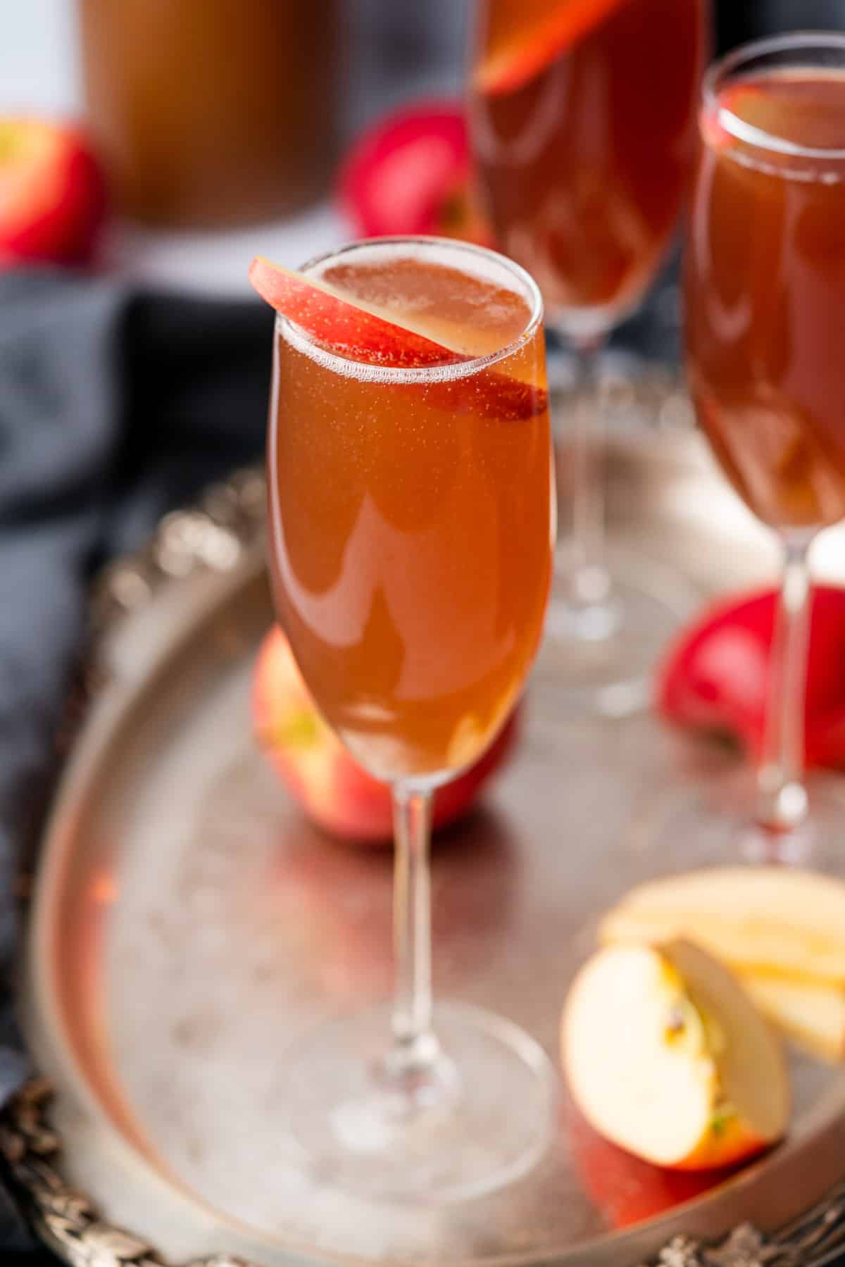 close up shot of an apple cider spritzer cocktail in a champagne flute