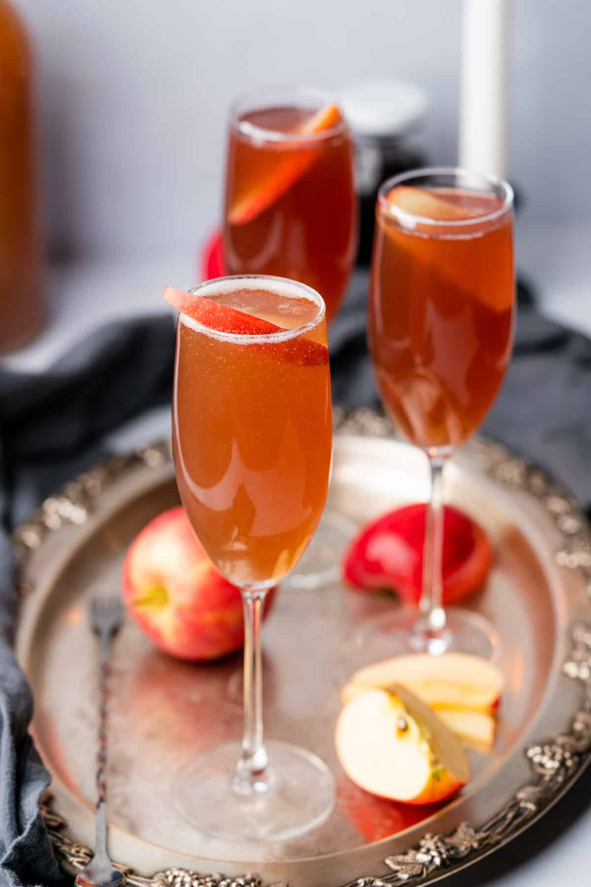 two close up shots of an apple cider mimosa with spiced rum