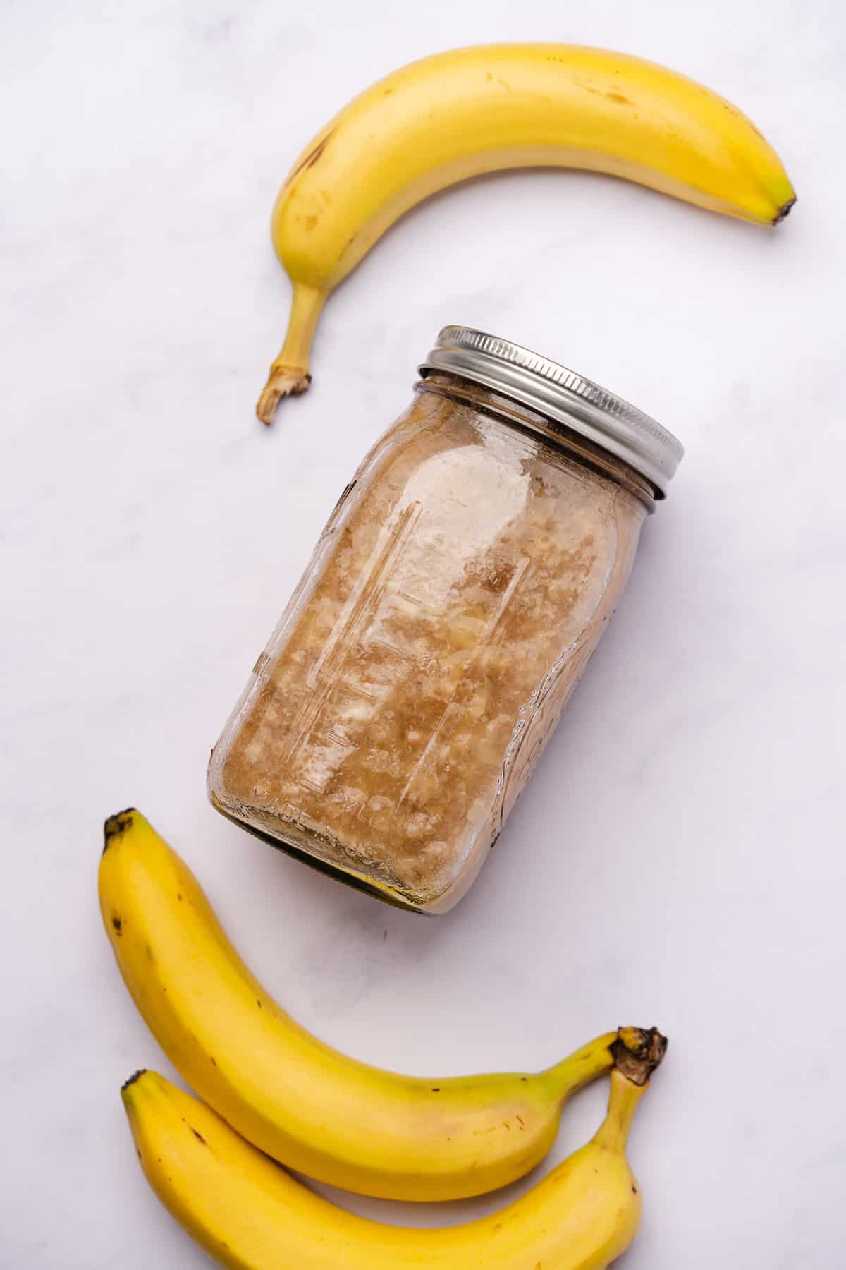mashed banana pieces in white rum inside of a mason jar