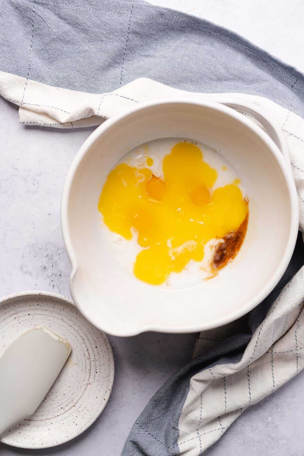 whisked eggs, milk, vanilla extract and melted butter in a bowl 