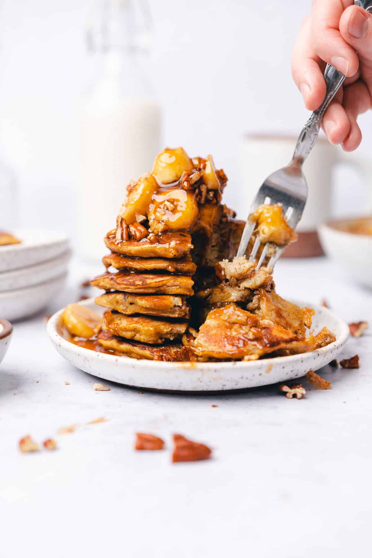 forkful of bananas foster pancakes from a stack