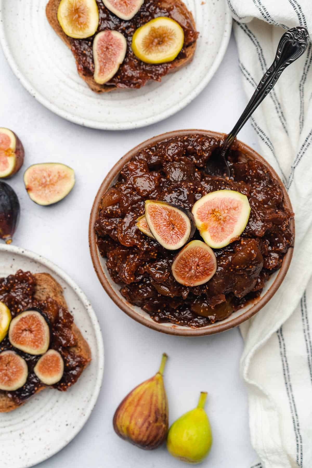 figs spreads in a bowl with fresh figs on top, and some on a plate with toast