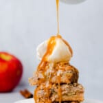 pouring salted caramel syrup on a stack of apple bars
