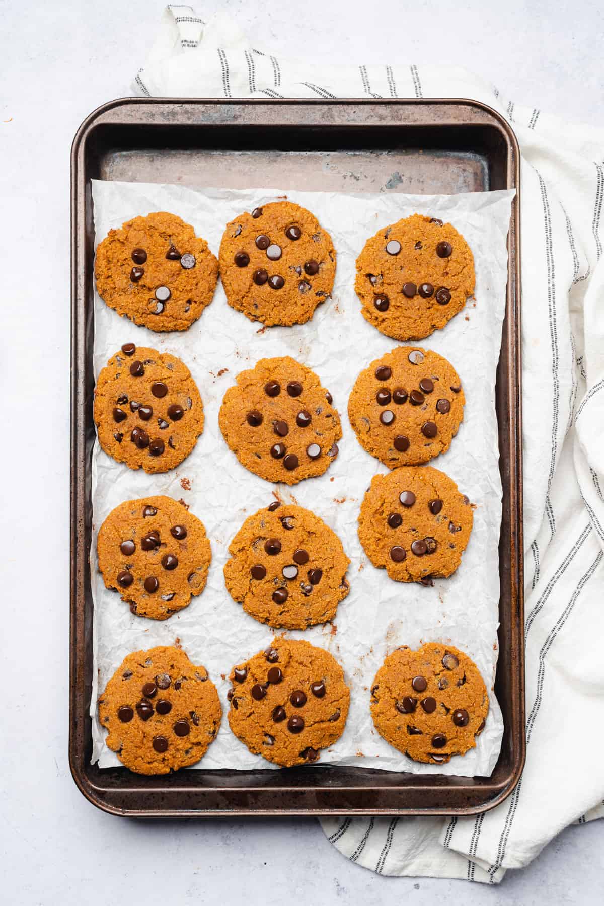 freshly baked keto chocolate chip cookies on a parchment lined baking sheet