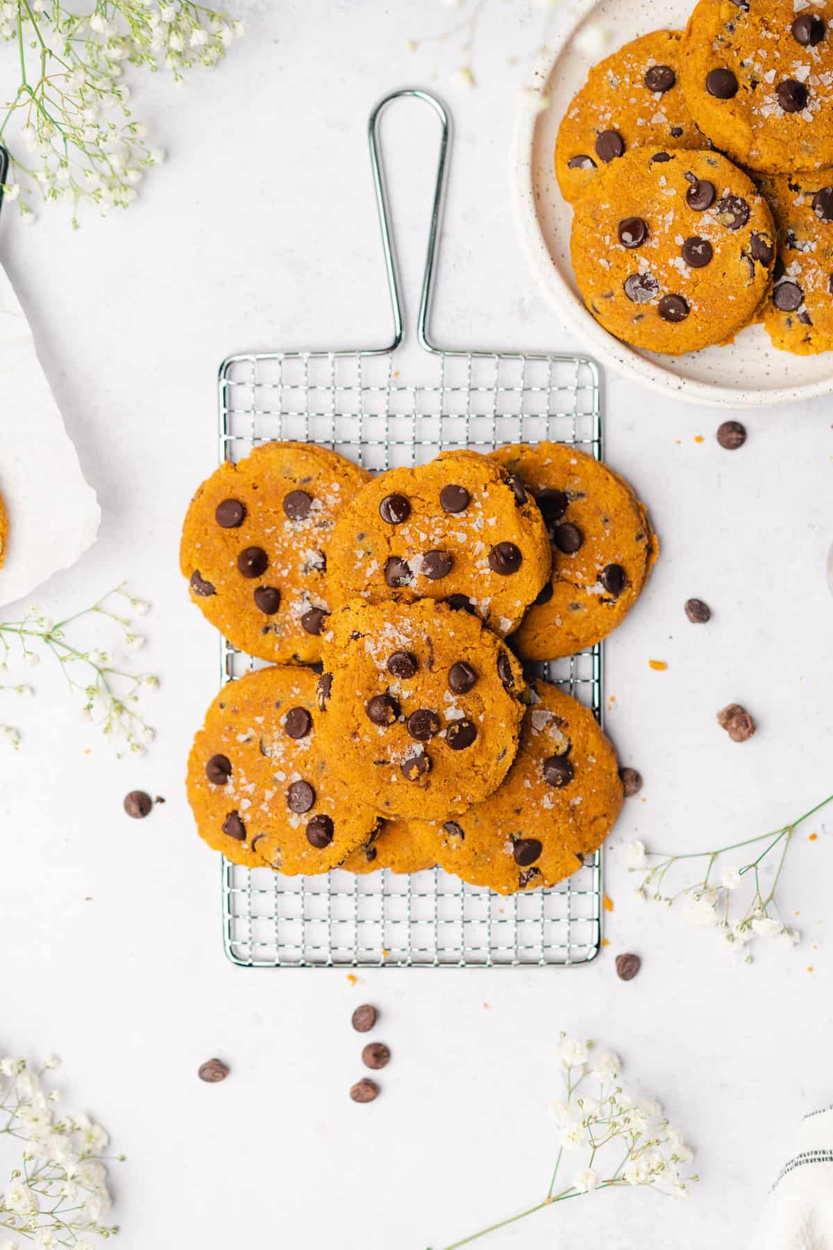 flat lay shot of keto pumpkin chocolate chip cookies surrounded by baby's breath flowers
