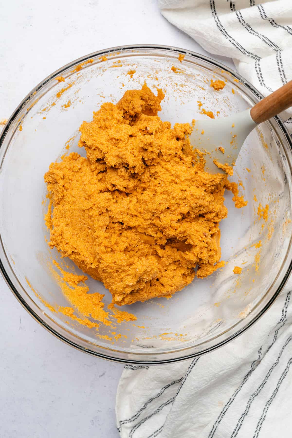 rubber spatula mixing together pumpkin cookie dough in a large bowl