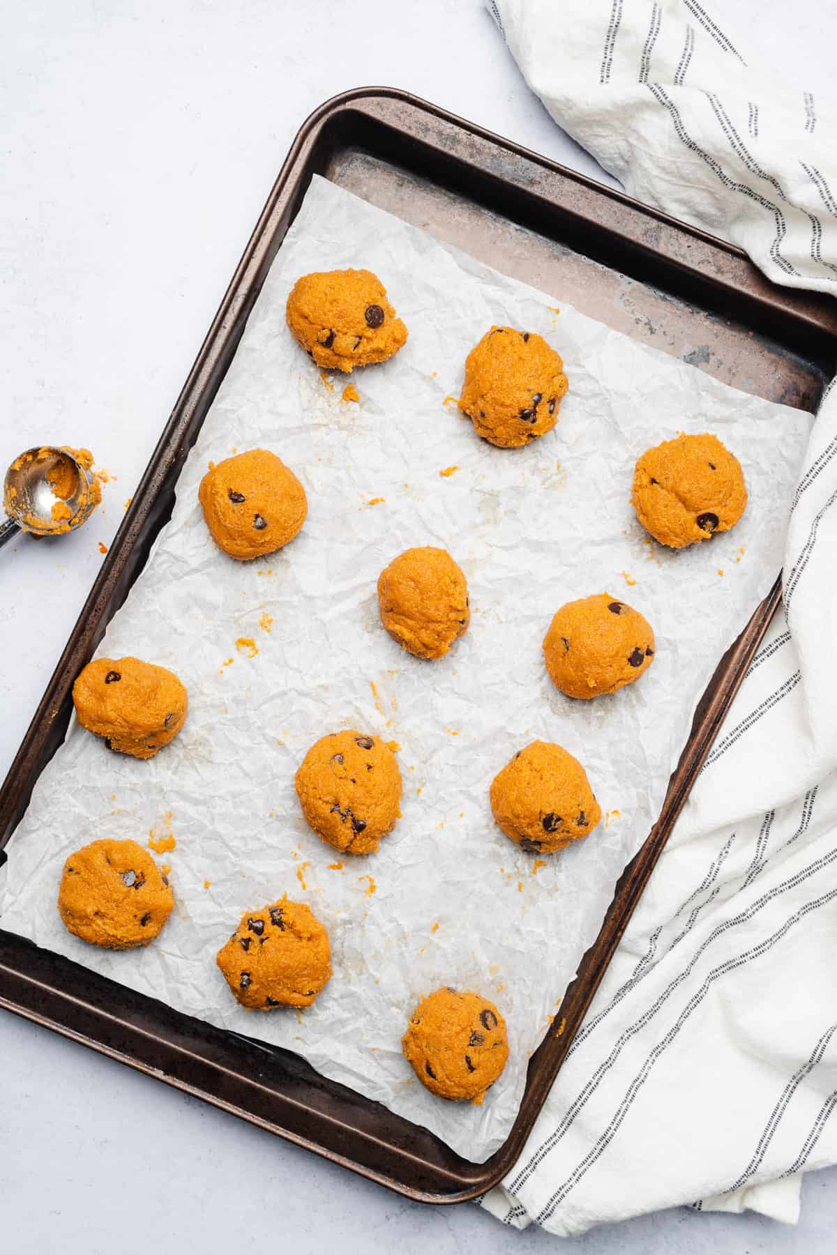 keto pumpkin chocolate chip cookie dough balls on a parchment lined baking sheet