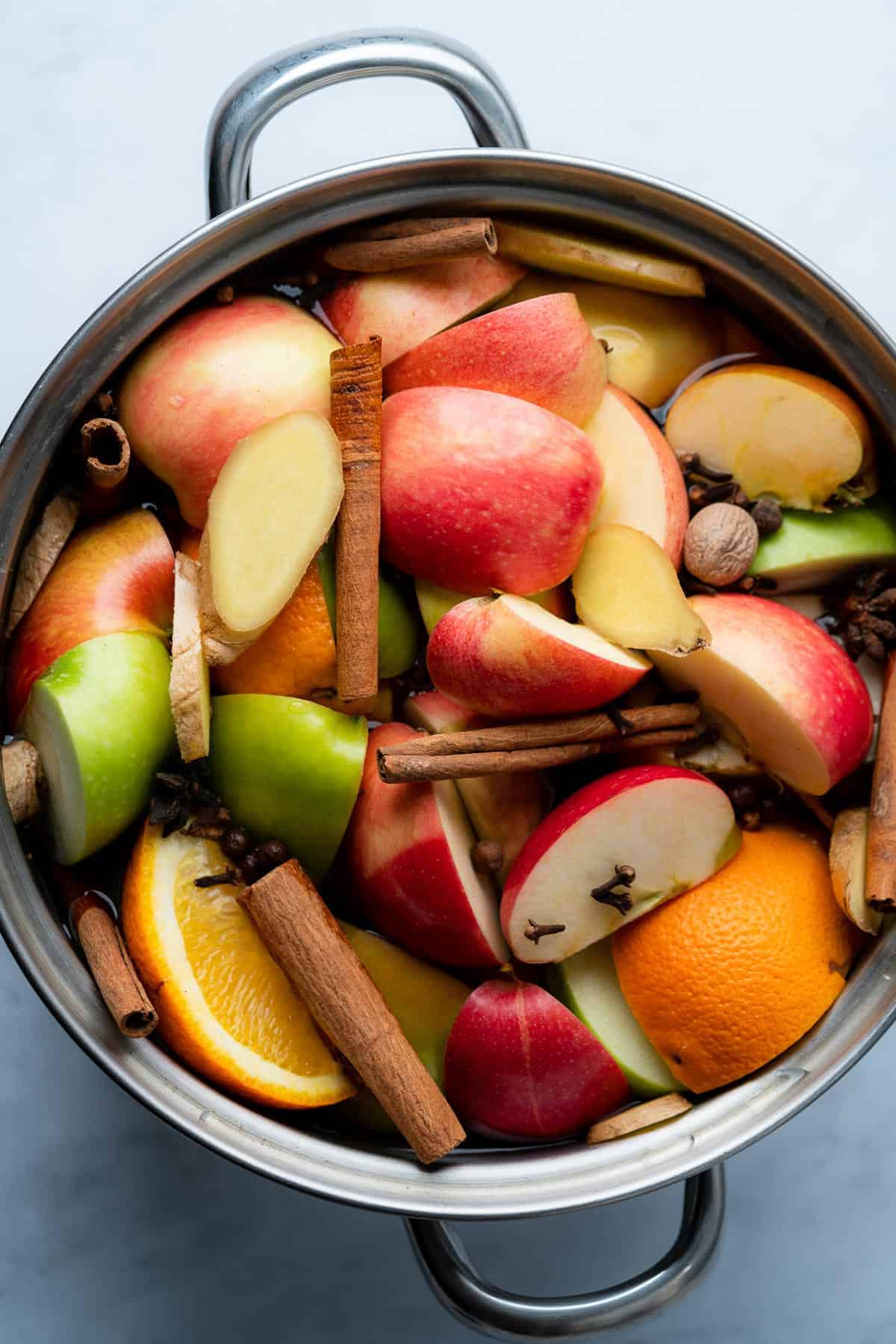 stock pot with apples oranges and spices