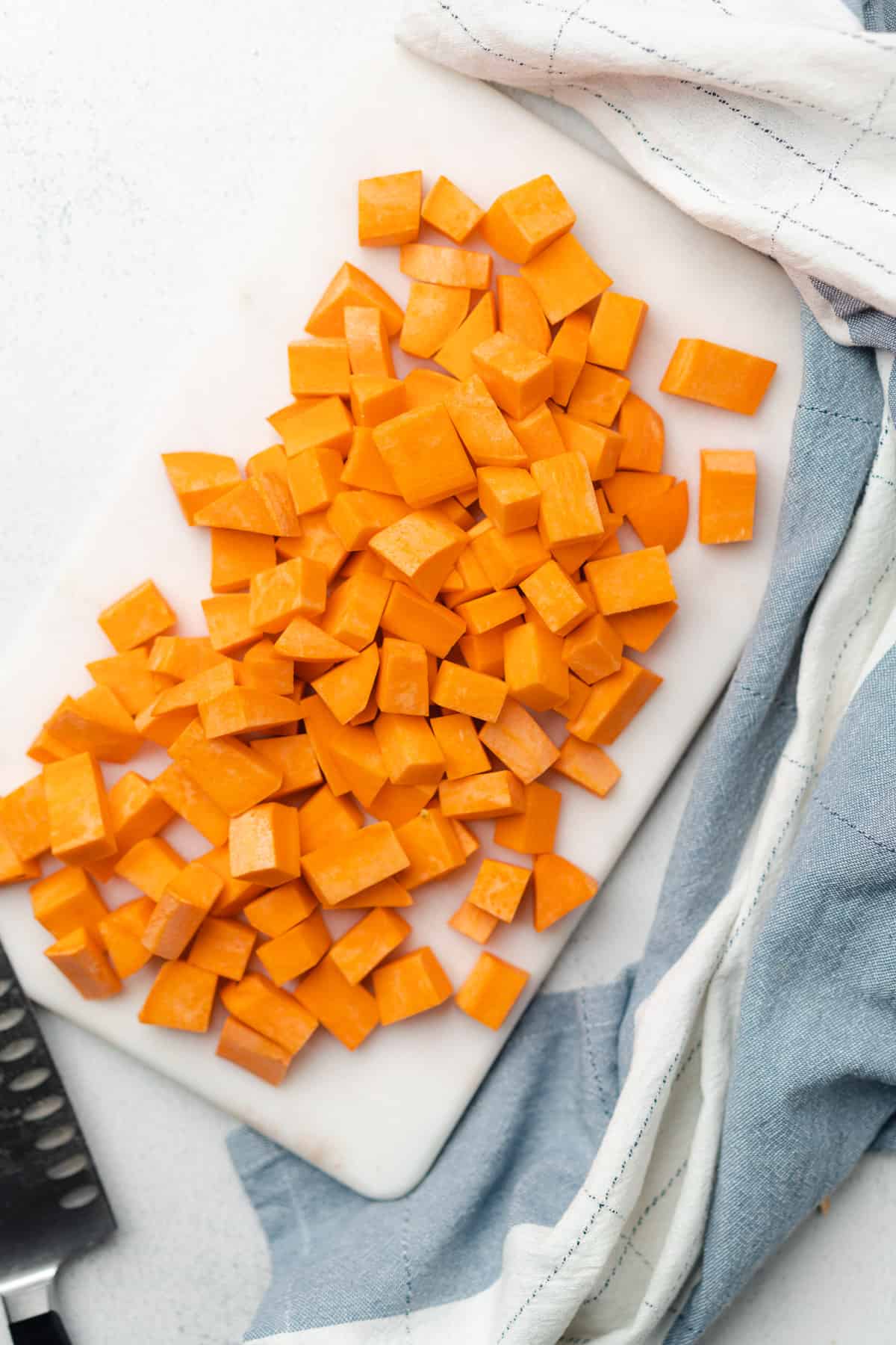 sweet potatoes cut into chunks on a cutting board