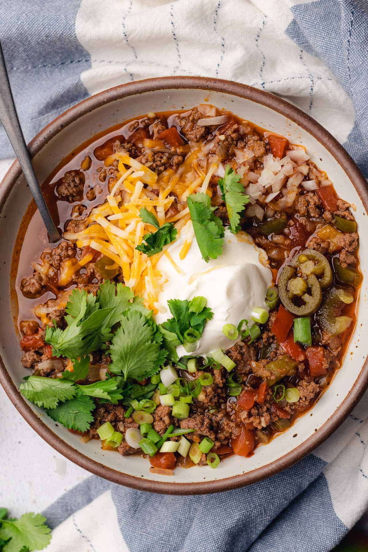 beanless chili low carb recipe with sour cream, green onions, cheese, cilantro, pickled jalapeños