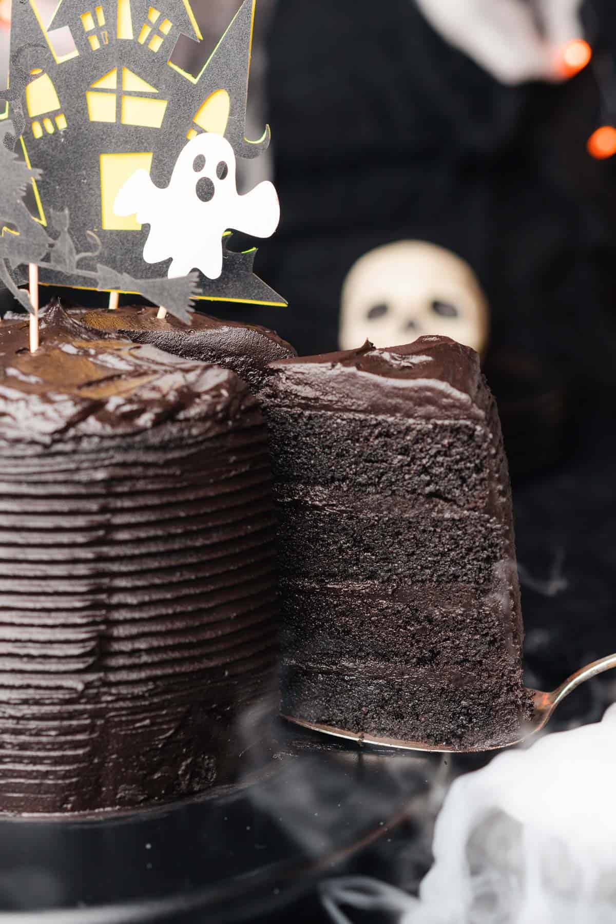 pulling out a large slice of black velvet cake with dark chocolate frosting