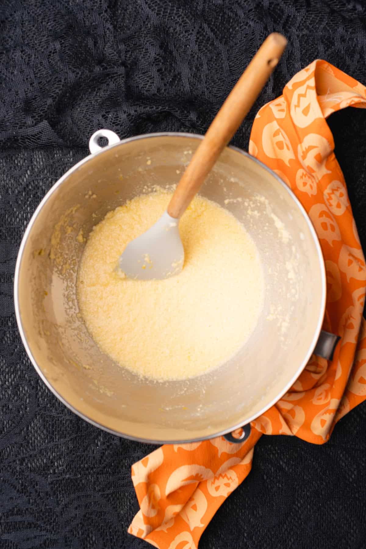 rubber spatula mixing together butter, sweetener and egg mixture in a bowl