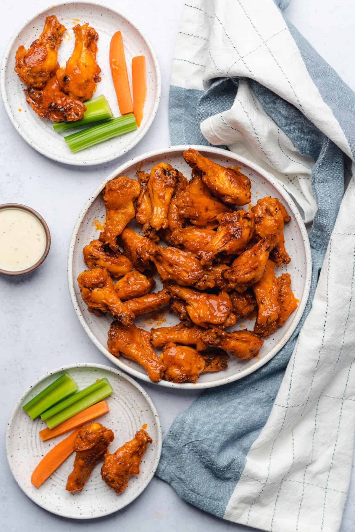 flat lay shot of crispy baked chicken wings served with celery, carrots and ranch dressing
