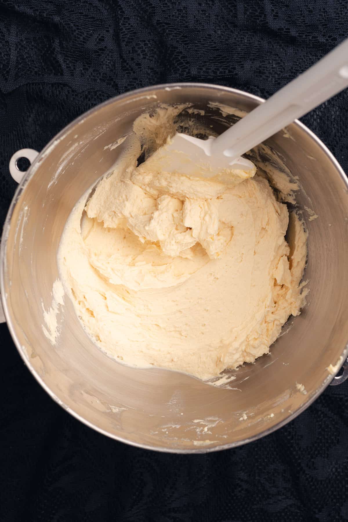 brown butter cream cheese frosting in a mixing bowl with a rubber spatula