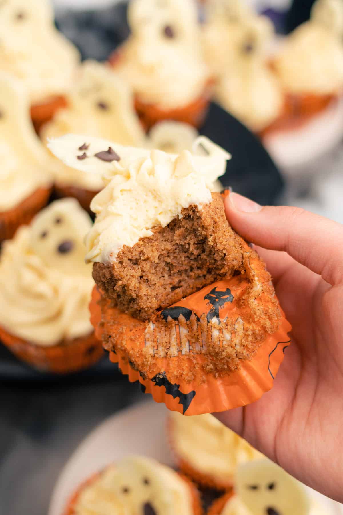 bite out of spiced cupcake with a ghost topping